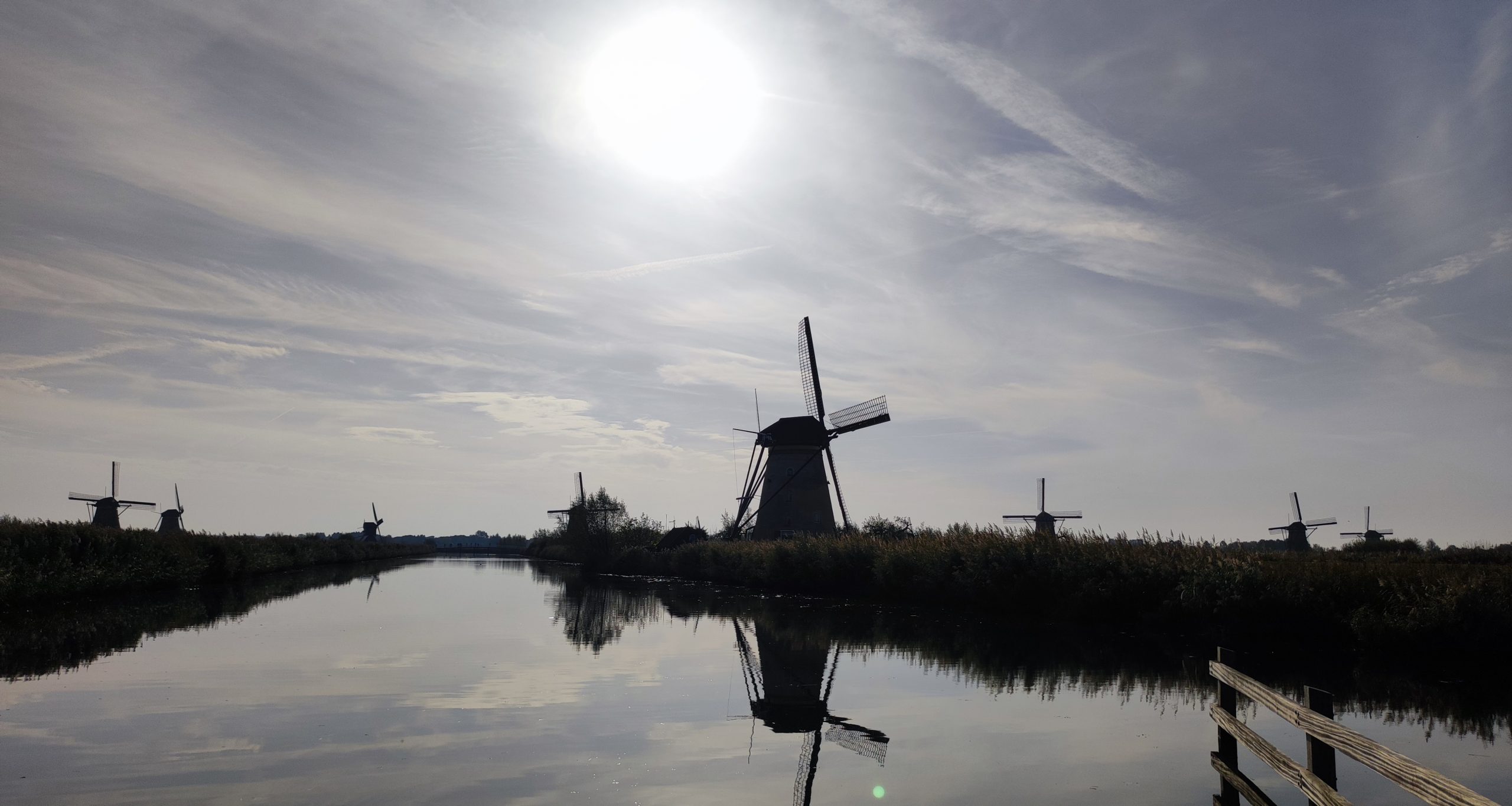 Molinos de viento de Kinderdijk a contraluz con reflejos en el río